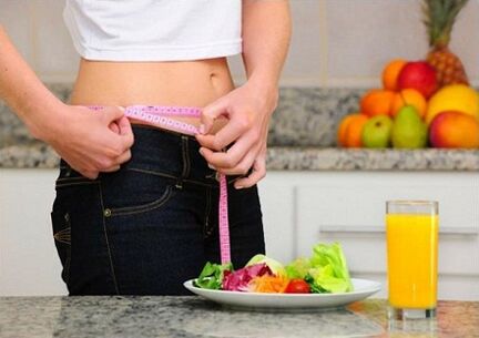 Une fille qui perd du poids grâce à un régime mesure son tour de taille